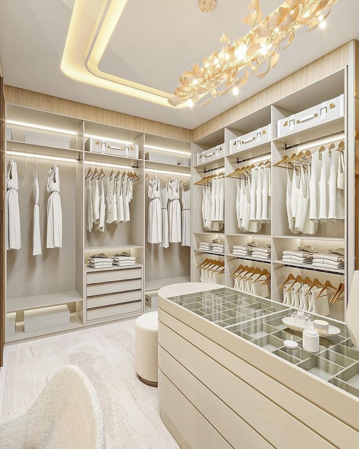 Custom walk-in closet with bright cabinetry, shelves, drawers, and island storage